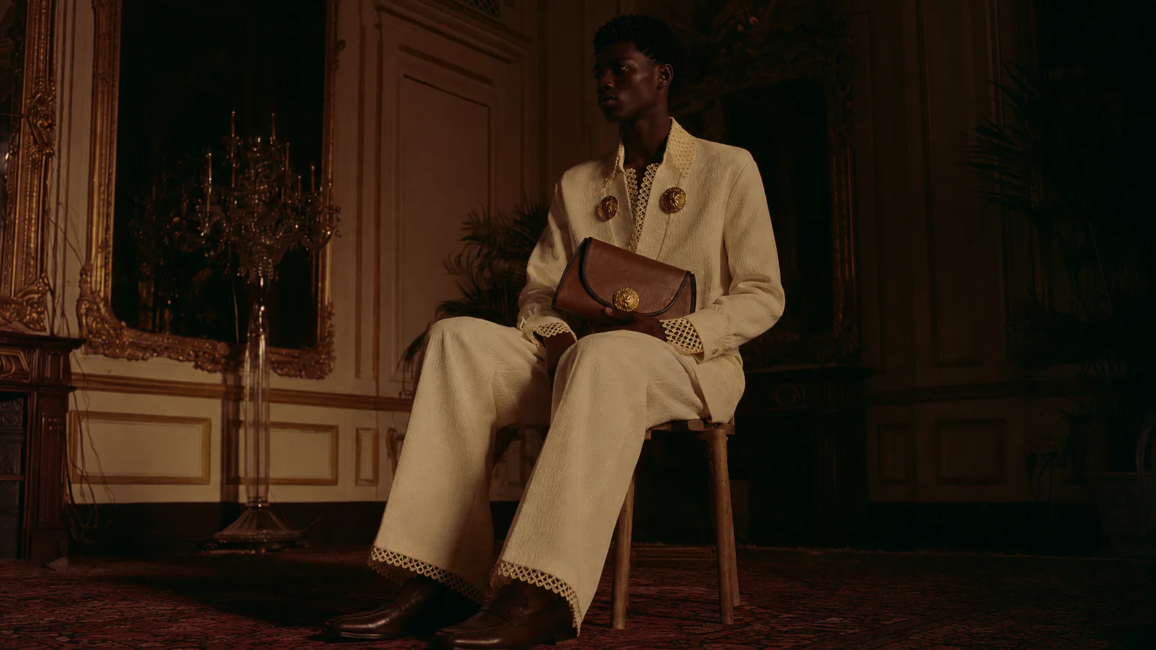 A man in ivory Obiageri tailoring seated in a heritage interior